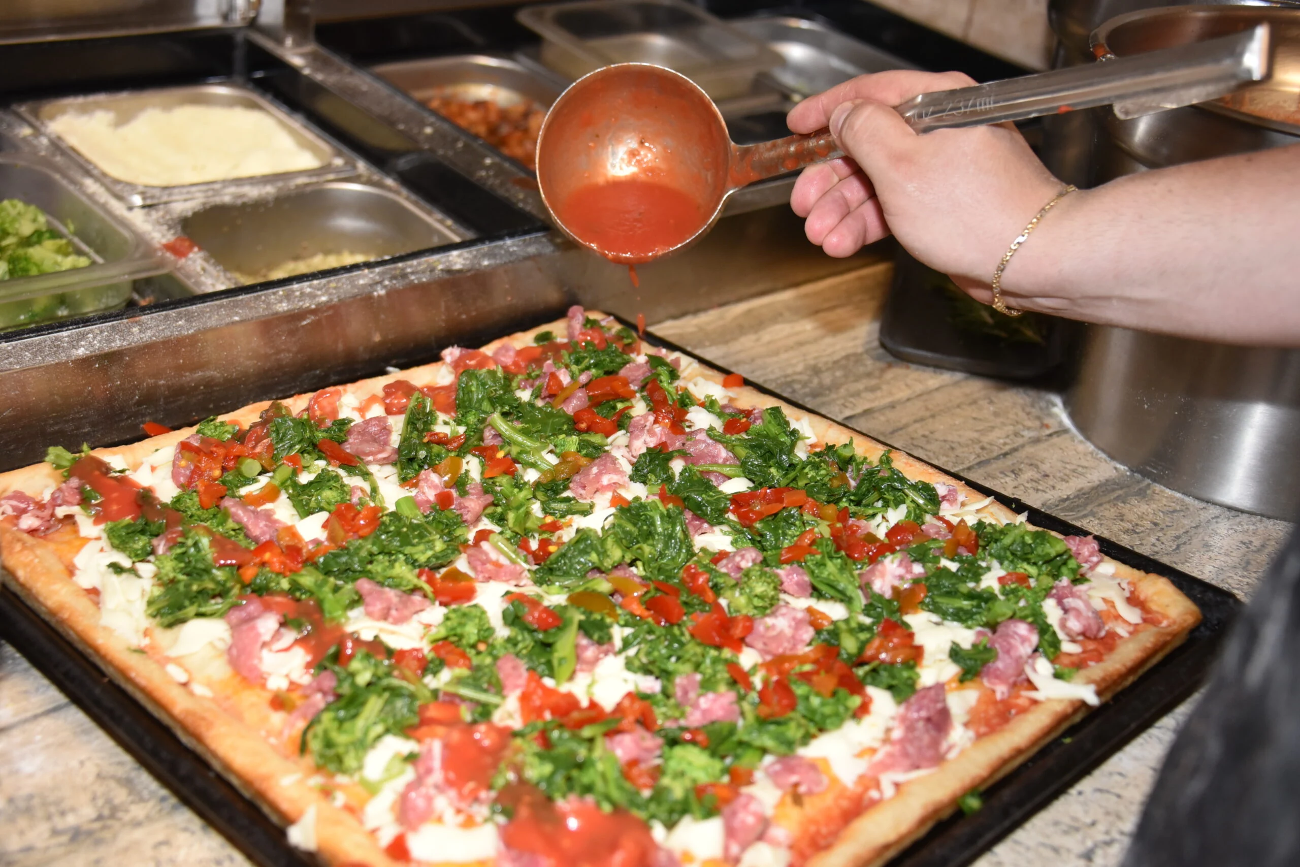 Square Sicilian pizza being prepared