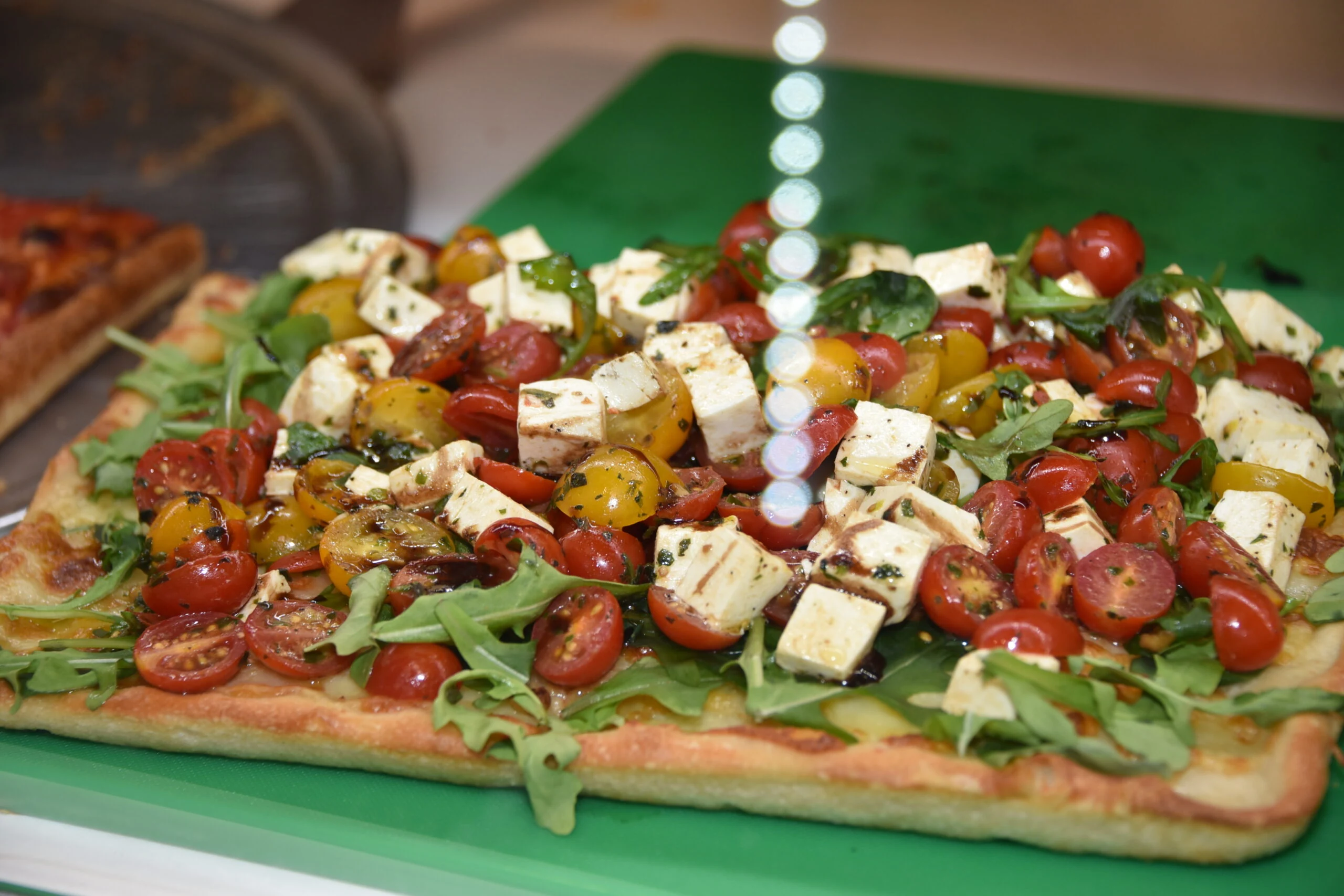 Caprese pizza with cherry tomatoes and feta